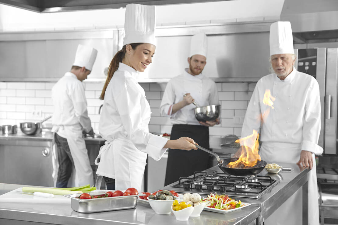 Plusieurs cuisiniers travaillent dans une cuisine professionnelle