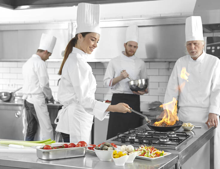 Plusieurs cuisiniers travaillent dans une cuisine professionnelle